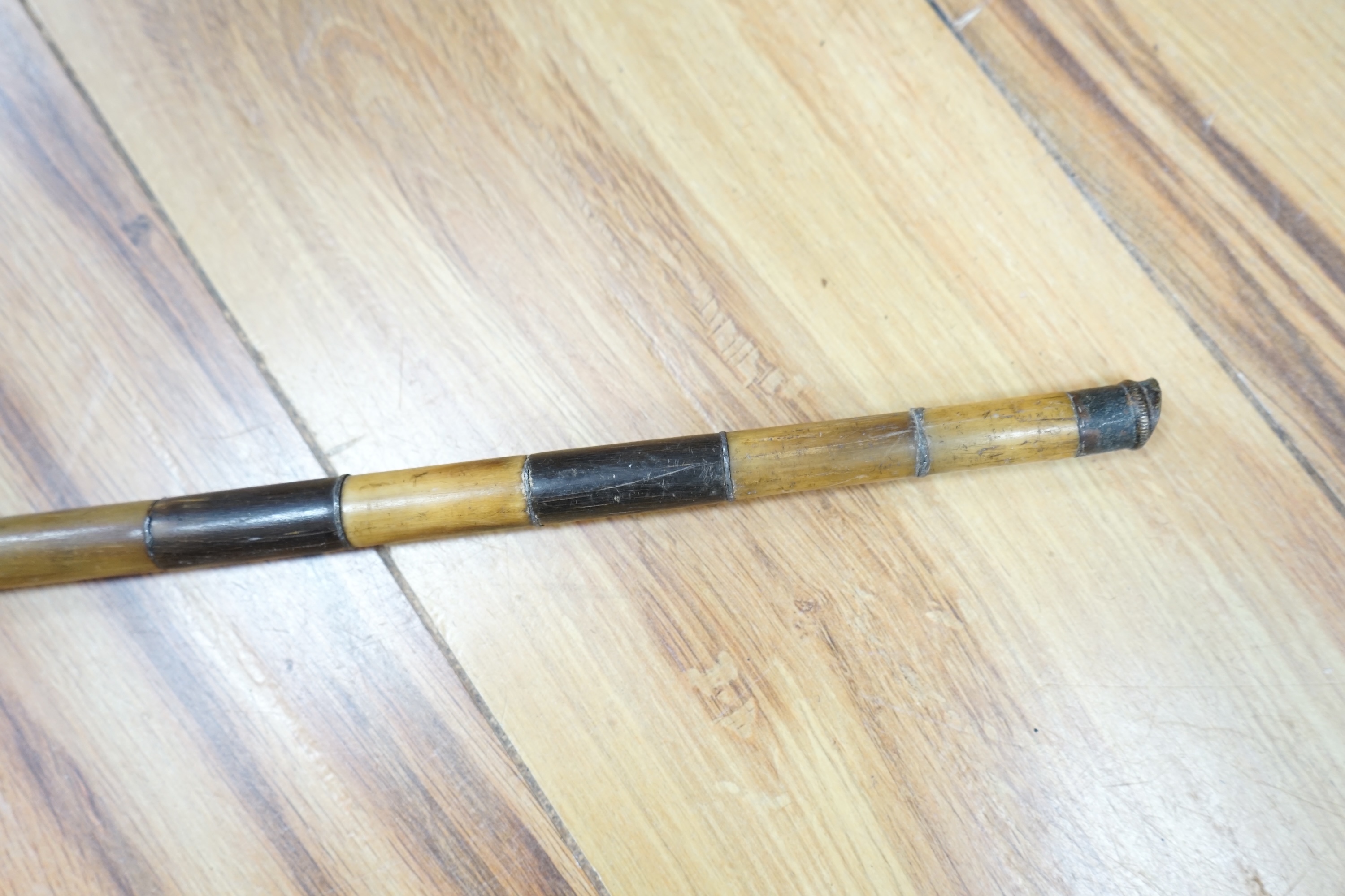 An African two colour banded horn walking stick with turned handle, 87cm in length. Condition - fair, bowed